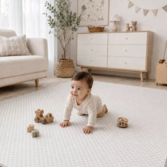 Soft padded baby play mat in neutral nursery, baby sitting and playing on Mountain Milestone design
