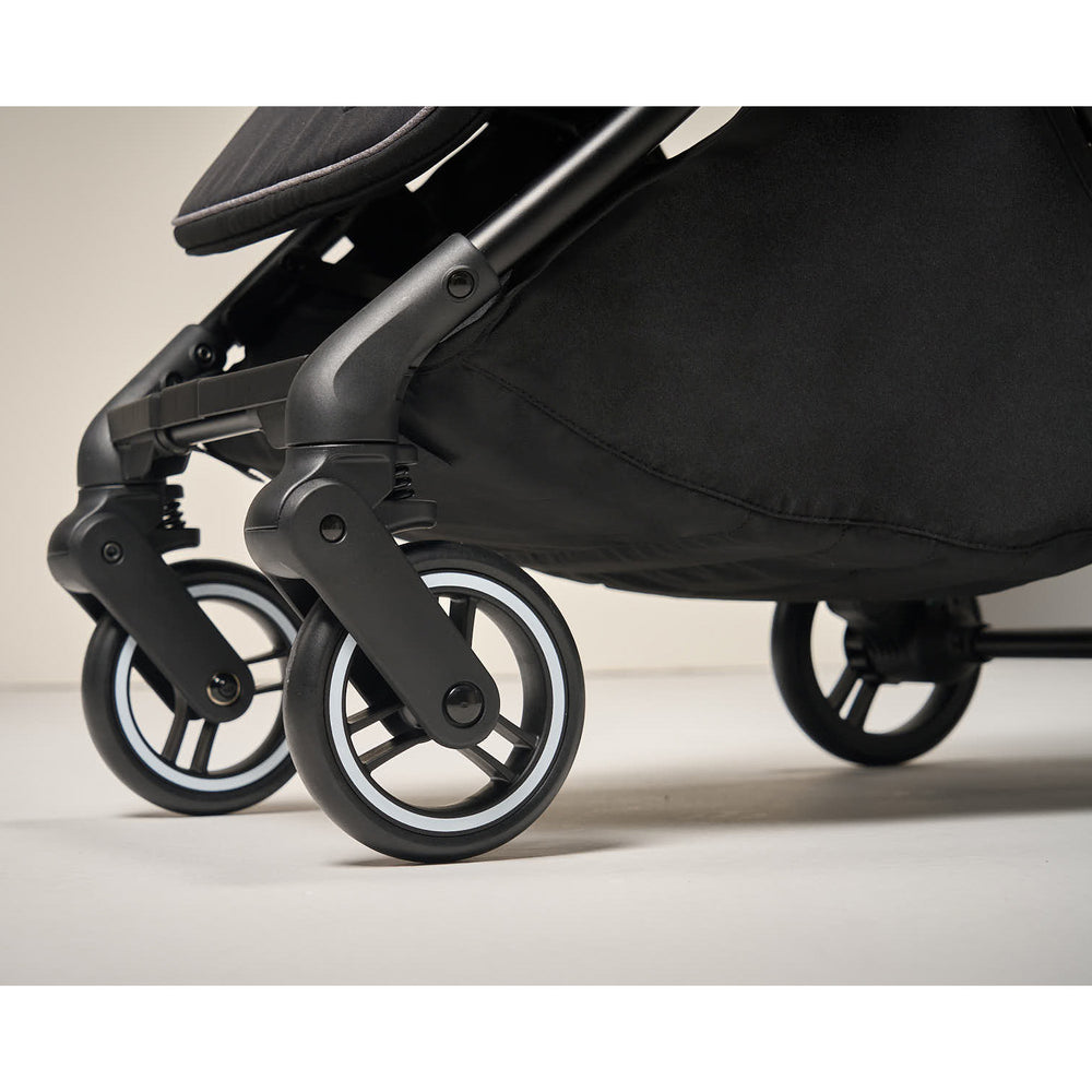 Close-up of stroller wheels with puncture-proof tires and suspension.