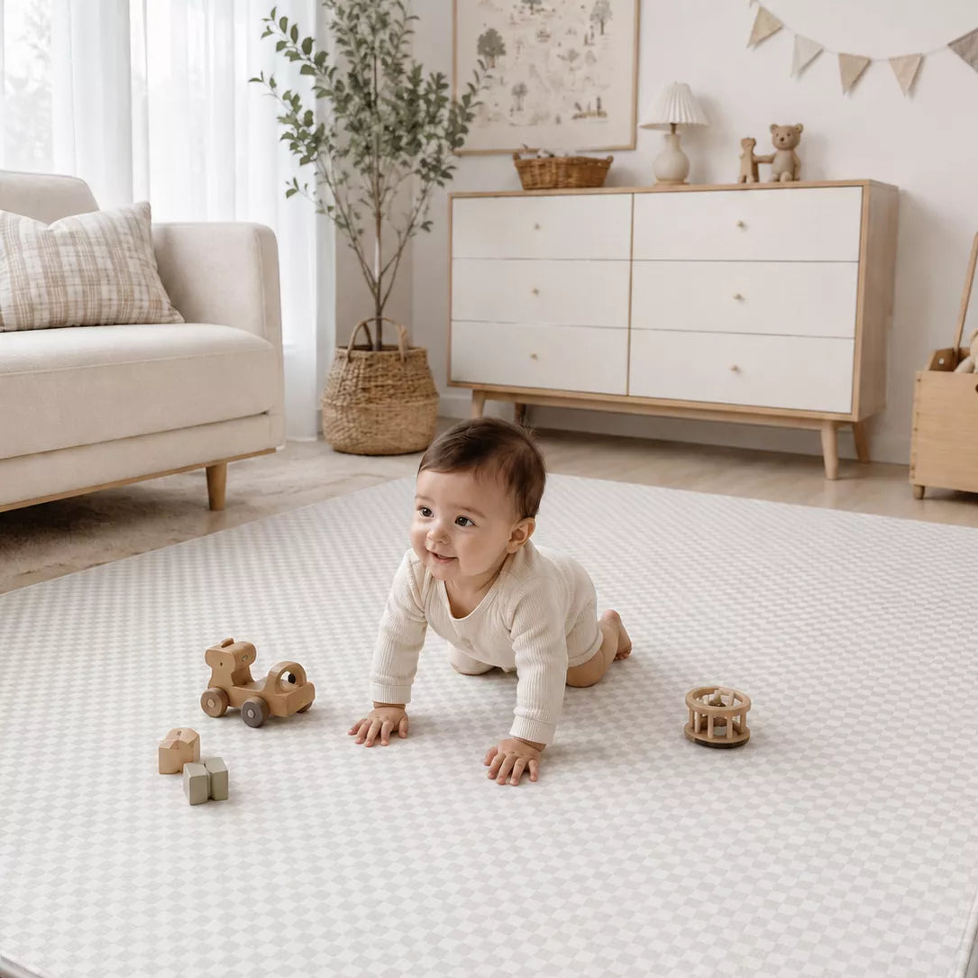 Soft padded baby play mat in neutral nursery, baby sitting and playing on Mountain Milestone design