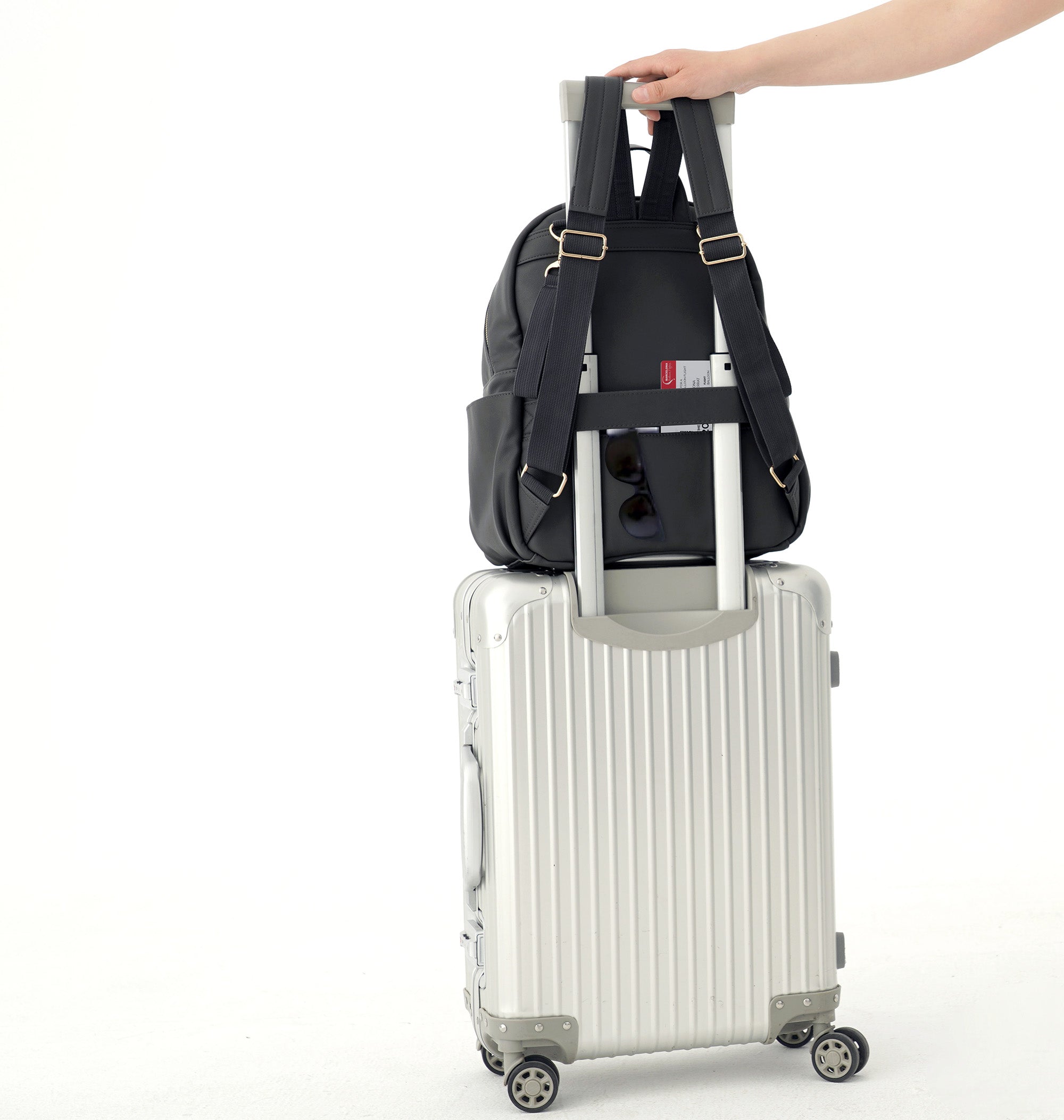 The Allis Backpack Changing Bag being effortlessly attached to a suitcase.