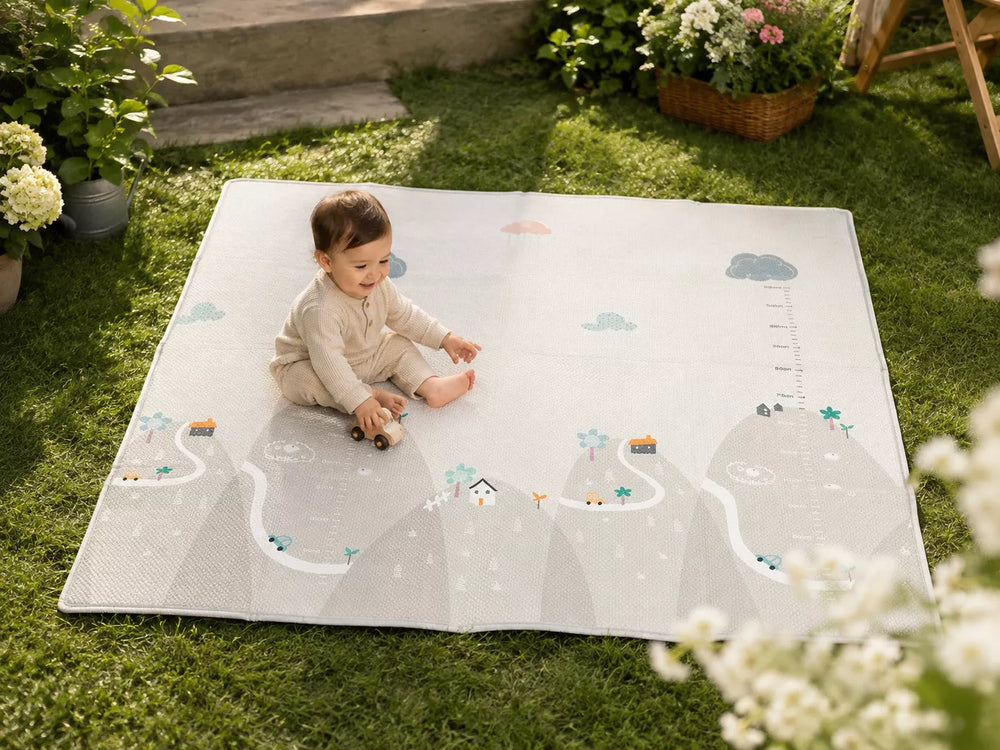 Extra large waterproof baby play mat laid on grass, toddler playing outdoors with Mountain pattern